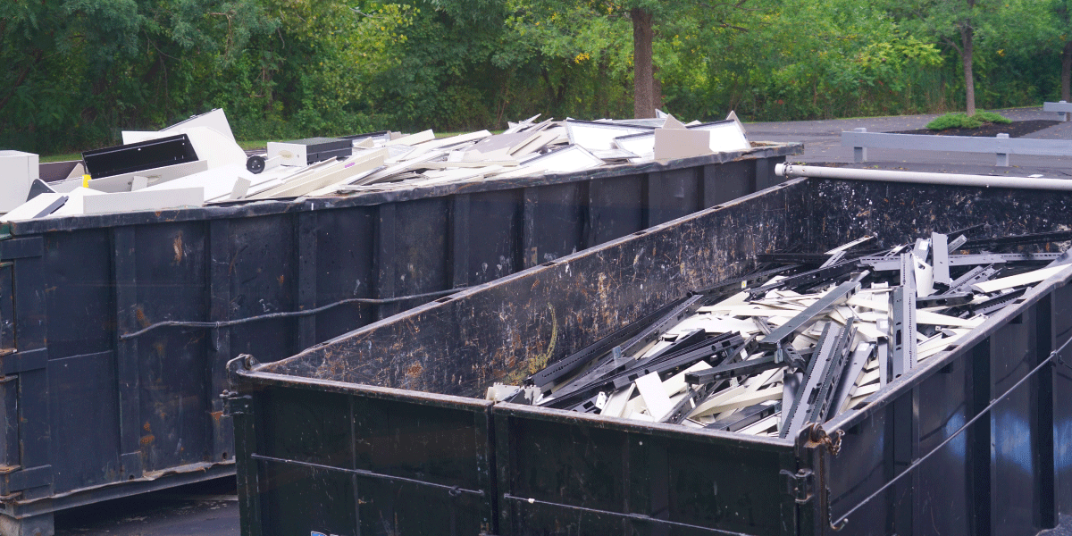two black dumpsters with debris inside